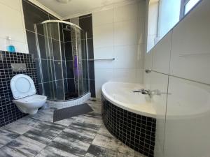 een badkamer met een bad, een toilet en een wastafel bij Zoe & Saint in Kaapstad