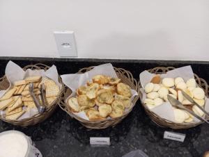 drei Körbe gefüllt mit verschiedenen Brotsorten und Snacks. in der Unterkunft HOTEL JP in Delfinópolis