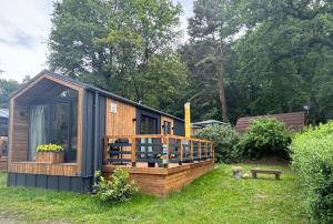 StuerTiny House Lotta - Auszeit-Oase am Plauer See的小屋设有大甲板,位于草地上