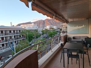 a balcony with tables and chairs and a view of a city at El Balcón de Roberta in Puerto de Santiago