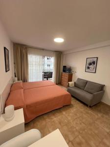 a bedroom with a large bed and a couch at Playa Jardín Bus terminal Pool in Puerto de la Cruz