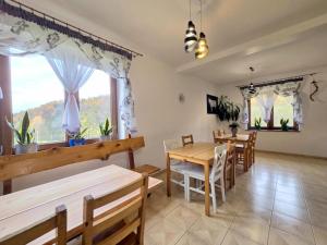 a dining room with tables and chairs and a window at Noclegi u Belli in Jugowice