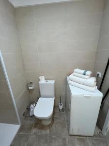 a bathroom with a white toilet and towels at Playa Jardín Bus terminal Pool in Puerto de la Cruz