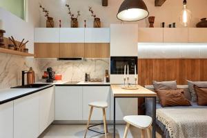 a kitchen with white cabinets and a table with stools at Studio in the Center of Burgas next to the See in Burgas City +13 photos