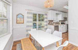 a white dining room with a white table and chairs at Seaside Haven in Myrtle Beach
