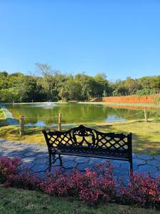 Colonia YguazúHabitación sin cocina en quinta Shizen的池塘前的公园长凳