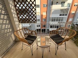 two chairs and a glass table on a balcony at Poseidon Breeze in Limassol