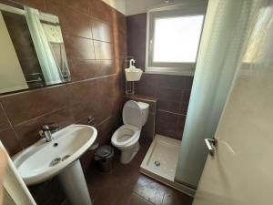 a bathroom with a sink and a toilet and a window at Poseidon Breeze in Limassol