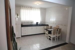a kitchen with a table and a white refrigerator at Apartamento amplo e confortável 1 in Maringá