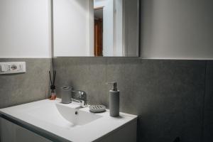 ein Badezimmer mit einem weißen Waschbecken und einem Spiegel in der Unterkunft I ricordi di San Pietro in Rom + 17 Fotos