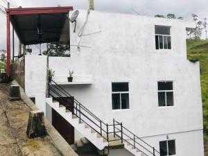 ein weißes Gebäude mit einer Seitentreppe in der Unterkunft River Line -Ella in Ella