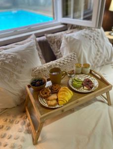 a tray of food on a table on a bed at Quinta da Hortigueira - Country House in Trancoso