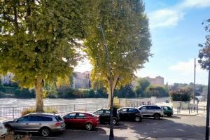a group of cars parked in a parking lot next to a river at Les Quais du Centre-Ville in Romans-sur-Isère