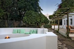 a fire pit in a backyard with green chairs at Firemasters House Historic Church Street in Tulbagh in Tulbagh