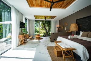 a bedroom with a large bed and a large window at Namu Garden Hotel & Spa - Adults Only in Puerto Viejo