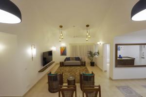 a living room with a couch and a table and chairs at Candolim's New 3BHK-Azure Luxury Penthouse Next to Starbucks, 6 minutes walk to Beach - By Lembranca in Candolim