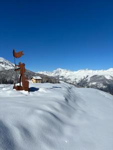 a statue in the snow with mountains in the background at Alpine Dream House - Chalet in Gressan