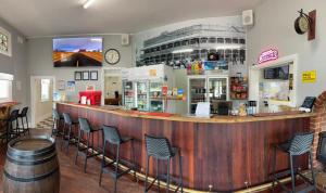 a bar in a restaurant with chairs and a clock at The Exchange Pingelly in Pingelly