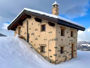 a building covered in snow in the snow at Alpine Dream House - Chalet in Gressan