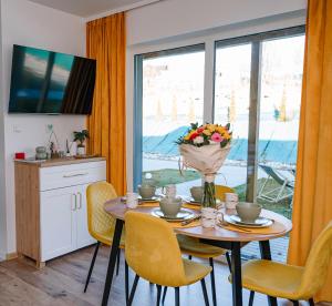 a dining room table with a vase of flowers on it at Apartament ZłotogórSKI Lądek-Zdrój in Lądek-Zdrój +29 photos