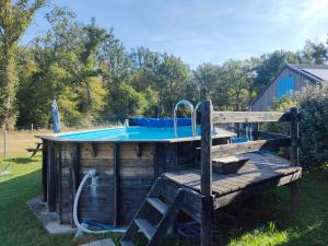a swimming pool with a wooden deck and aitating at Pisseloup in Gouise