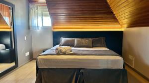 a bedroom with a large bed with a wooden ceiling at Hotel Glamour da Serra in Gramado +63 photos