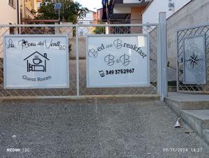 three signs on a fence in front of a house at la rosa dei venti 2 in Acri