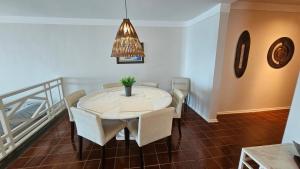 a dining room with a white table and chairs at Linda Vista do Mar - Espaçoso - Praia Pitangueiras in Guarujá