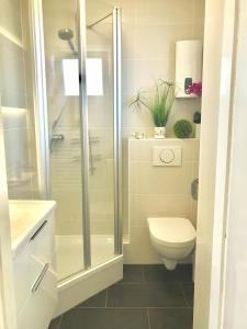a white bathroom with a shower and a toilet at Ostseeblick in Scharbeutz +18 photos