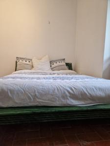 un letto con lenzuola e cuscini bianchi in una stanza di Une chambre Salle de bain Wi-Fi a Bédarrides