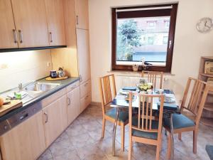 Una cocina con una mesa y sillas y un fregadero. en Maisonette Ferienwohnung - Stuth Barth, en Barth