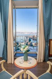 a vase of flowers on a table in front of a window at La Rada B&B in Bacoli