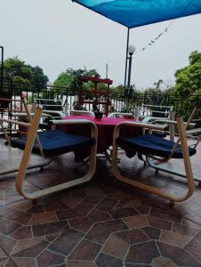 Una mesa con sillas y una sombrilla en un patio. en Mi Hábitat, en Asunción