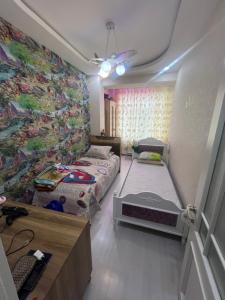a bedroom with two beds and a wall with a mural at дом in Baku