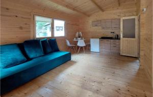 a living room with a blue couch and a kitchen at Stunning Home In Pobierowo With Kitchen in Pobierowo