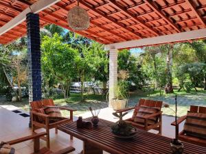 a patio with a wooden table and chairs on a porch at Vivenda Xawã in Corumbau