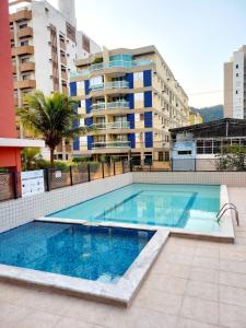 a swimming pool in the middle of a building at Um luxo de apartamento na Enseada in Guarujá