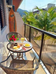 a table and chairs on a balcony with food on it at Um luxo de apartamento na Enseada in Guarujá +17 photos