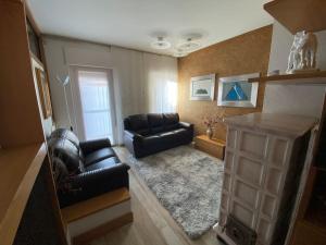 a living room with two leather couches and a table at Casa Giusy in Albiano