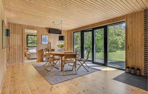 d'une salle à manger avec une table, des chaises et des portes coulissantes en verre. dans l'établissement Nice Home In Knebel With House Sea View, à Knebel