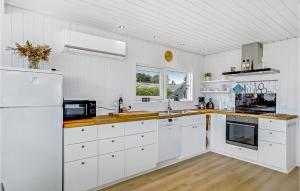 a white kitchen with white cabinets and a sink at Awesome Home In Øster Assels With Sauna in Øster Assels