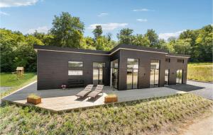 a modular home with a wooden deck and benches at Nice Home In Sjølund With Sauna in Sjølund +17 photos