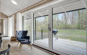 a screened in porch with a chair and windows at 3 Bedroom Pet Friendly Home In Oksbøl in Oksbøl