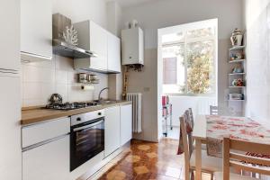 a kitchen with white cabinets and a table and a window at Casariosa, centro Rimini in Rimini