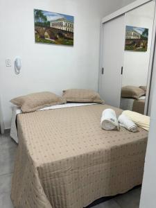 un letto in una camera da letto con due scarpe bianche di Léka Collegiate 2 adultos a São João del Rei