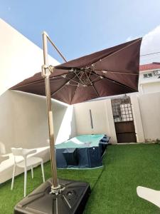 a brown umbrella sitting on the grass in a yard at Kuantan Setali ROOMSTAY by Iconique in Kuantan +72 photos