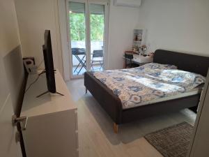 a bedroom with a bed and a television on a table at Apartment Park Melada in Zadar