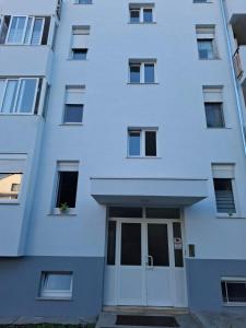 a white building with a large door in front at Apartment Park Melada in Zadar