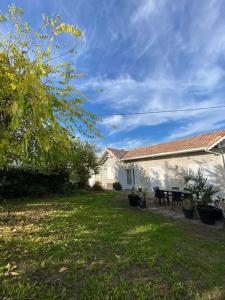 a house with a picnic table in a yard at Charmante maison familiale -Jardin -WIFI -Parking in Mérignac