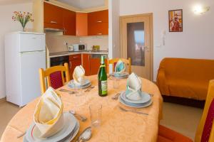 a dining room table with a bottle of wine on it at Apartments Bojka in Promajna